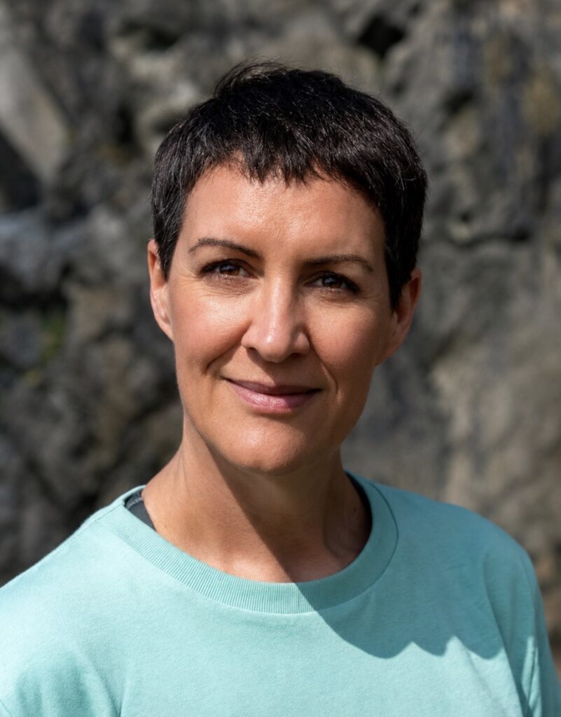 A headshot of Nadine Dyson wearing a teal T shirt